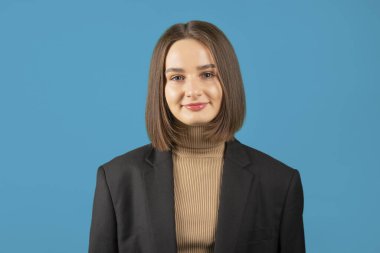 Genç bayan öğrenci mavi arka planda sakin bir portre.