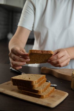 Kahvaltı hazırlayan kadın. Fıstık ezmeli ekmek..