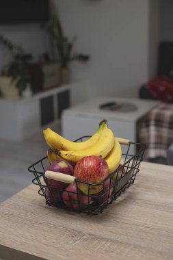 Sağlıklı atıştırmalıklar için meyve sepeti: muz ve elma.