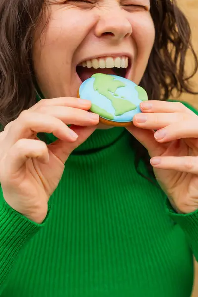 Earth Day Concept Woman Bites Cookie Shape Earth Royalty Free Stock Photos