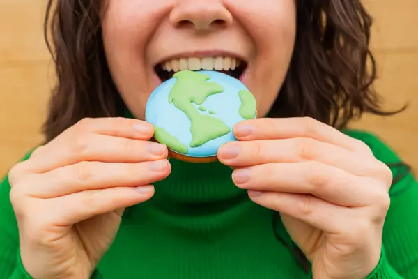 Earth Day Concept Woman Bites Cookie Shape Earth Stock Picture