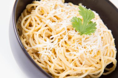 Sarı biberli spagetti rendelenmiş mozzarella peyniri ile kaplanmış kişniş ile süslenmiş. 