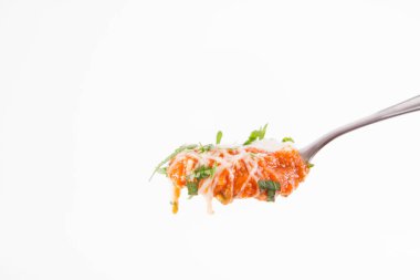 Kremayla servis edilen İtalyan domates çorbası, mozarella peyniri ve taze maydanoz kasede, kaşıkta, beyaz arka planda.