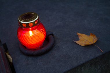 Gece bir mezarlıkta yanan adak mumu.