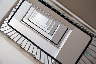 Metal parmaklıklı bir apartmanın merdivenleri yukarı doğru görünüyor.