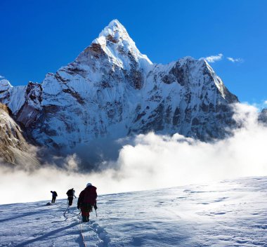 Ama Dablam Dağı, Everest Bölgesi, Khumbu Vadisi, Nepal Himalayaları 'ndaki Everest ana kampına kadar üç yürüyüşçünün montajı.