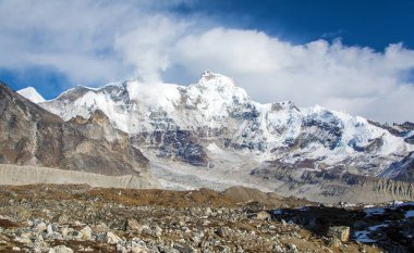 Cho Oyu ve Ngozumba buzulu yakınlarındaki bulutlar arasında Hungchi tepesinin 7029 metre manzarası, Sagarmatha ulusal parkı, Khumbu vadisi, Nepal Himalayaları dağları