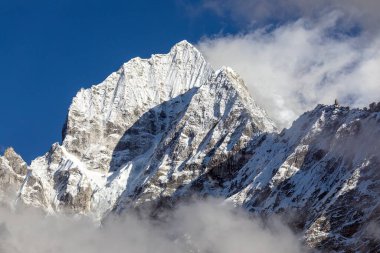 Couds 'un ortasında Thamserku Dağı, Khumbu Vadisi, Solu Khumbu, Nepal Himalayaları Dağları' ndaki Everest Dağı ana kampına giden güzel karlı dağ.