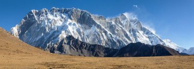 Lhotse Zirvesi, Lhotse Shar Dağı ve Nuptse Dağı güneydeki kayalar Nepal Himalayalar 'daki öküz çayırlarının tepesinde yer alır.