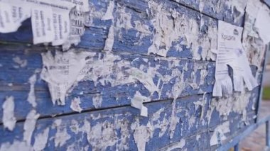 Üzerinde kağıt reklamlar ve telefon numarası olan eski mavi bir ilan tahtası. İşsizlik krizi yönetim kurulu kağıt konsepti. Yanlamasına 4km 'lik yüksek kalite görüntü