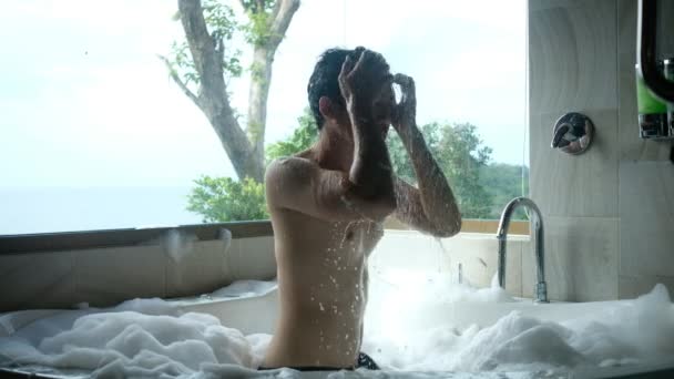 年轻人在有自然背景的私人浴缸里洗澡 — 图库视频影像