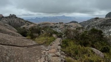 Andringitra ulusal parkı, Madagaskar, dağ manzarası, yüksek tepelerden inen patika. Andringitra dağlarında turist gezisi. Madagaskar vahşi doğası.