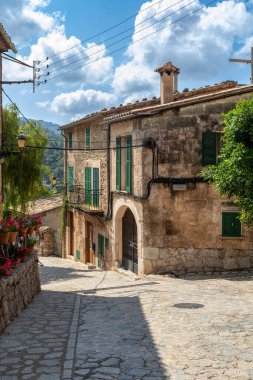 Valldemossa 'da dar bir sokakta bir sürü çiçek var. Mimari hazineler - Valldemossa 'nın tarihi merkezi ve Akdeniz mimarisinin büyüsü. Balear Adaları Mallorca İspanya.