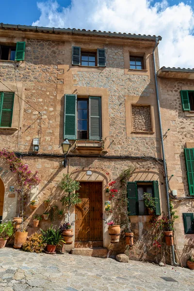 stock image Narrow street in the Valldemossa with lots of ubiquitous flowers. Architectural treasures - Magic of Valldemossa's historic center and its Mediterranean architecture. Balearic Islands Mallorca Spain.