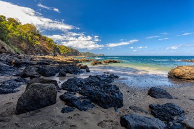Playa Ocotal ve Pasifik Okyanusu dalgaları kayalık kıyılarda, El Coco Kosta Rika. Ünlü şnorkel plajı. Resimli cennet tropikal manzarası. Pura Vida konsepti, egzotik tropikal ülkeye seyahat.
