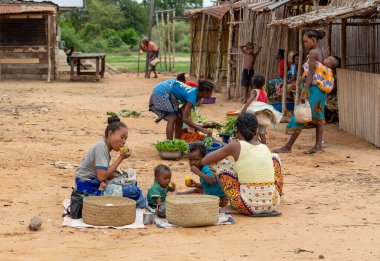 Bekopaka, Madagaskar - 6 Kasım 2022: Malagasy 'li kadın ve çocukları sokakta sebze satıyor.