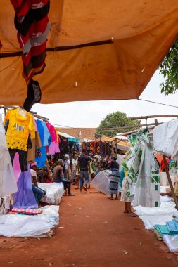 Mandoto, Madagaskar - 9 Kasım 2022: Mandoto şehrinde canlı renklerde çeşitli kıyafetler satan satıcılarla dolu hareketli bir sokak pazarı.