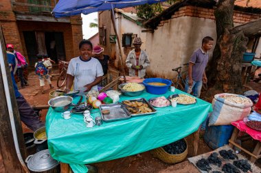 Mandoto, Madagaskar - 9 Kasım 2022: Mandoto şehrindeki sokak pazarı, satıcılar ve sıradan insanların alışveriş yaptığı ve sosyalleştiği yer. Kadın yerel özel yemekler satıyor..