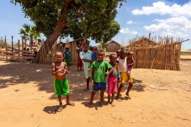 Port Bac Belo Sur Tsiribihina, Madagaskar - 4 Kasım 2022: Mania nehri yakınlarındaki bir turiste bakan meraklı bir grup çocuk. Çocuklar nehir kıyısında kırsal bir köyde yaşıyorlar..