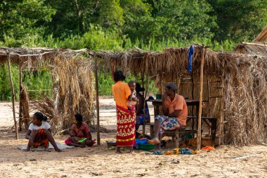 Feribot limanı Bekopaka, Madagaskar - 4 Kasım. 2022: Kulübesinin önündeki gölgede dinlenen Malagasy 'li kadınlar.