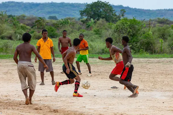 BEKOPAKA, MADAGASCAR - 6 Kasım 2022: Bir grup genç Madagaskar 'ın batısındaki kırsal bir köy olan Bekopaka' da bir toprak alanda futbol oynuyor. Oyun yerel halk arasında popüler bir eğlencedir..