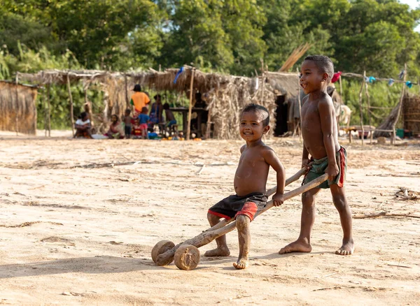 Feribot limanı Bekopaka, Madagaskar - NOVEMBER 4 2022: Erkekler Bekopaka feribot limanında basit bir oyuncakla eğleniyor.