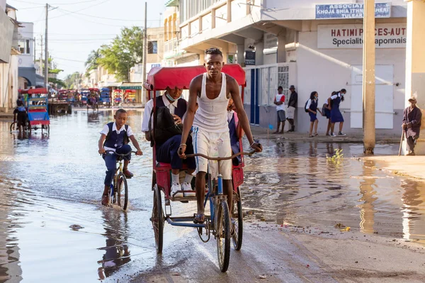 Toliara, Madagaskar - 21 Kasım. 2022: Malagasy yolcularının olduğu geleneksel triportör bisikleti, para kazanmanın yollarından biri. Madagaskar sokaklarında günlük yaşam.