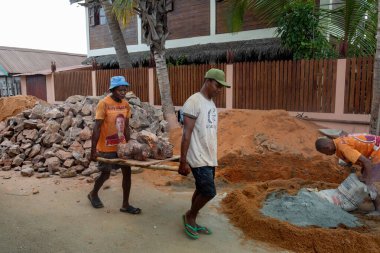 Morondava, Madagaskar - 3 Kasım 2022: Malagasy 'li adamlar sıkı çalışıyor, elle inşaat taşları taşıyorlar.