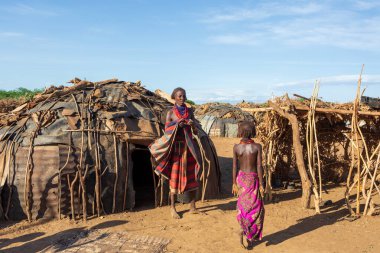 Omorate, Omo Vadisi, Etiyopya - 11 Mayıs 2019: Dasanesh kabilesinden bir kadın geleneksel kulübenin önünde. Daasanach Etiyopya, Kenya ve Güney Sudan 'da yaşayan Hristiyan etnik gruptur.