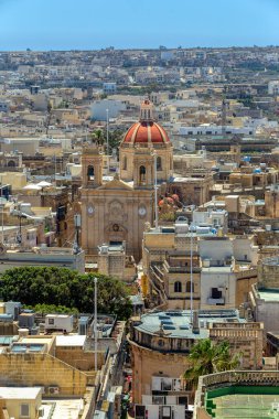 Victoria 'daki tarihi Kale, Gozo' nun teras çatılarının ortasındaki Aziz George Bazilikası 'nı görmek için çarpıcı bir bakış açısı sunuyor. Gozo Malta