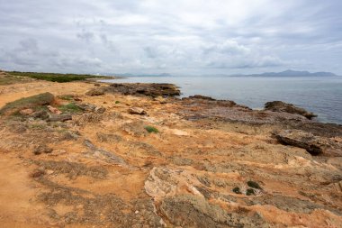 Şehrin yakınındaki doğal plaj Can Picafort 'ta arka planda küçük bir deniz feneri var. Balear Adaları Mallorca İspanya. Seyahat acentası tatil kavramı.