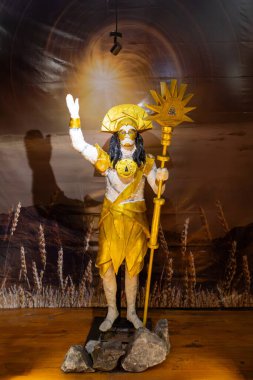 Majestic golden statue of Muisca, called Chibcha. Indigenous people in salt mine cathedral. Historic religious figure holding ceremonial staff in underground Salt Cathedral of Zipaquira, Colombia. clipart