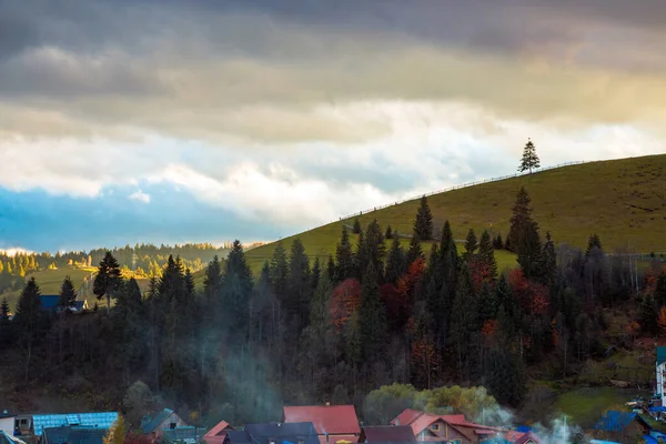 Engin mavi bulutlu gökyüzü ile sonbaharda Ukrayna 'da bir kayak merkezindeki güzel panoramik resimli dağ manzarasında altın gün batımının geniş bir görüntüsü.