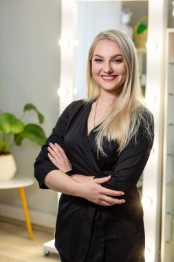 Parlak masaj spa stüdyosunda siyah cüppeli beyaz bir masör. Arka planda lambalar olan bulanık bir ayna.