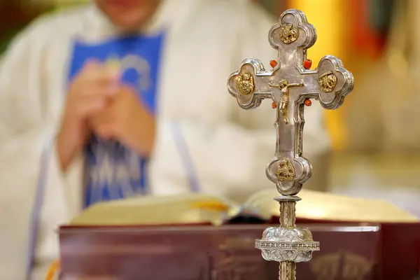 stock image Holy Cross with Jesus Christ on the altar during the Holy Mass, the priest in the background and empty space for text