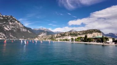 Güneşli bir günde İtalya 'da, Torbole yakınlarında Garda Gölü' nde yelken açan rüzgar sörfçüleri.