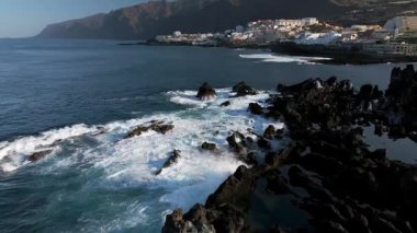 Los Gigantes 'in kayalık sahillerinde köpüklü deniz dalgalarının hava manzarası. Puerto de Santiago, Playa de la Arena ve Los Gigantes, Tenerife, Kanarya Adaları, İspanya.