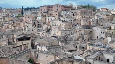 İtalya, Matera - 28.04.2025: Matera 'nın Sassi ilçesinin güneşli bir günde tüy taşı evleriyle panoramik manzarası, Matera, İtalya. 