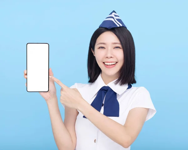 Mooie Stewardess Toont Mobiele Telefoon Met Leeg Scherm Blauwe Achtergrond — Stockfoto