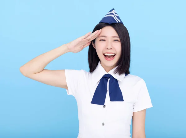 Gelukkig Jong Stewardess Saluting Geïsoleerd Blauwe Achtergrond — Stockfoto