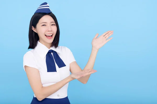 Mooie Stewardess Toont Iets Blauwe Achtergrond — Stockfoto