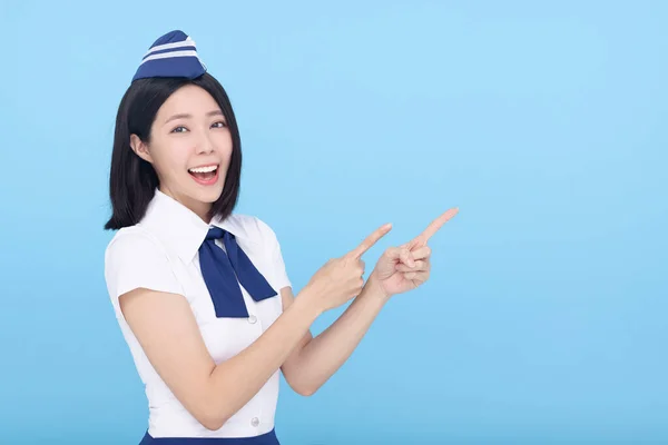 Happy Beautiful Stewardessa Airline Pokazuje Coś Niebieskim Tle — Zdjęcie stockowe