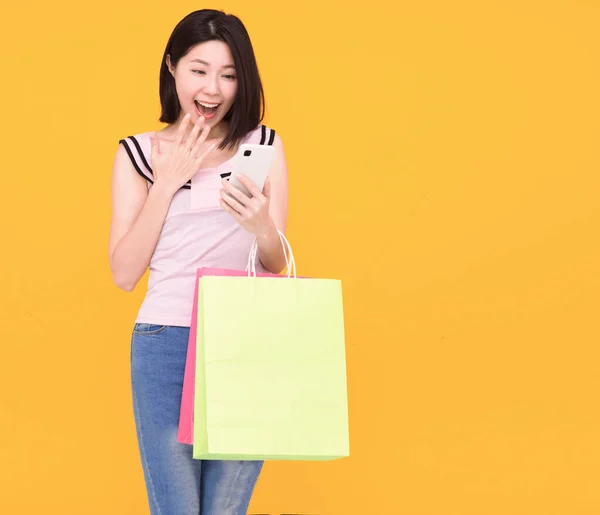Šťastná Mladá Žena Sleduje Mobilní Telefon Drží Nákupní Tašky — Stock fotografie