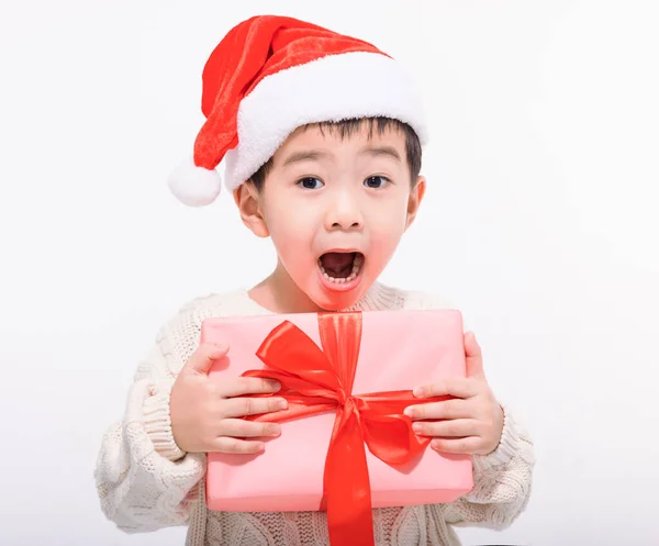 Şaşkın Küçük Çocuk Noel Baba Şapkası Giymiş Hediyesini Tutuyor — Stok fotoğraf