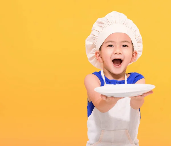 Happy Little Boy Chef Uniform Showing Empty Dish Yellow Background — Stock Photo, Image