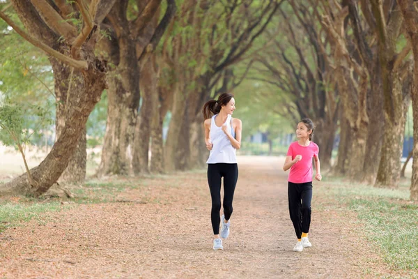快乐的妈妈和女儿在公园里奔跑 — 图库照片