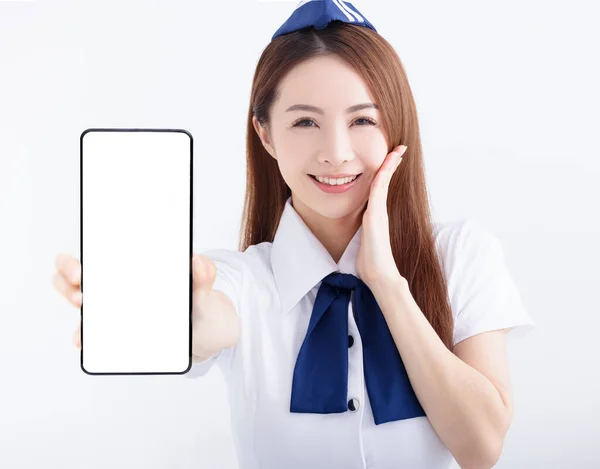 美丽的航空公司空姐在白色背景上用空白屏幕显示手机 — 图库照片