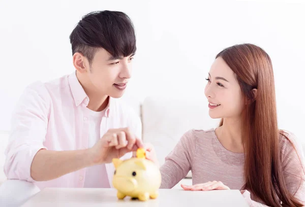 持有Piggybank的年轻亚洲夫妇为未来存钱 — 图库照片
