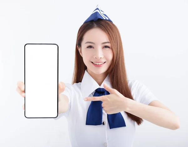 白い背景に空白の画面で携帯電話を示す美しい航空会社スチュワーデス — ストック写真
