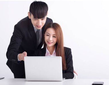 İş ekibi dizüstü bilgisayar kullanıyor ve ofiste birlikte çalışıyorlar.